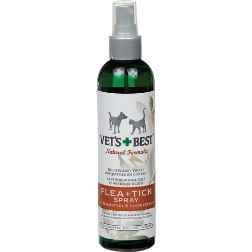 Green spray bottle of flea and tick treatment for pets with natural peppermint oil and clove extract formula
