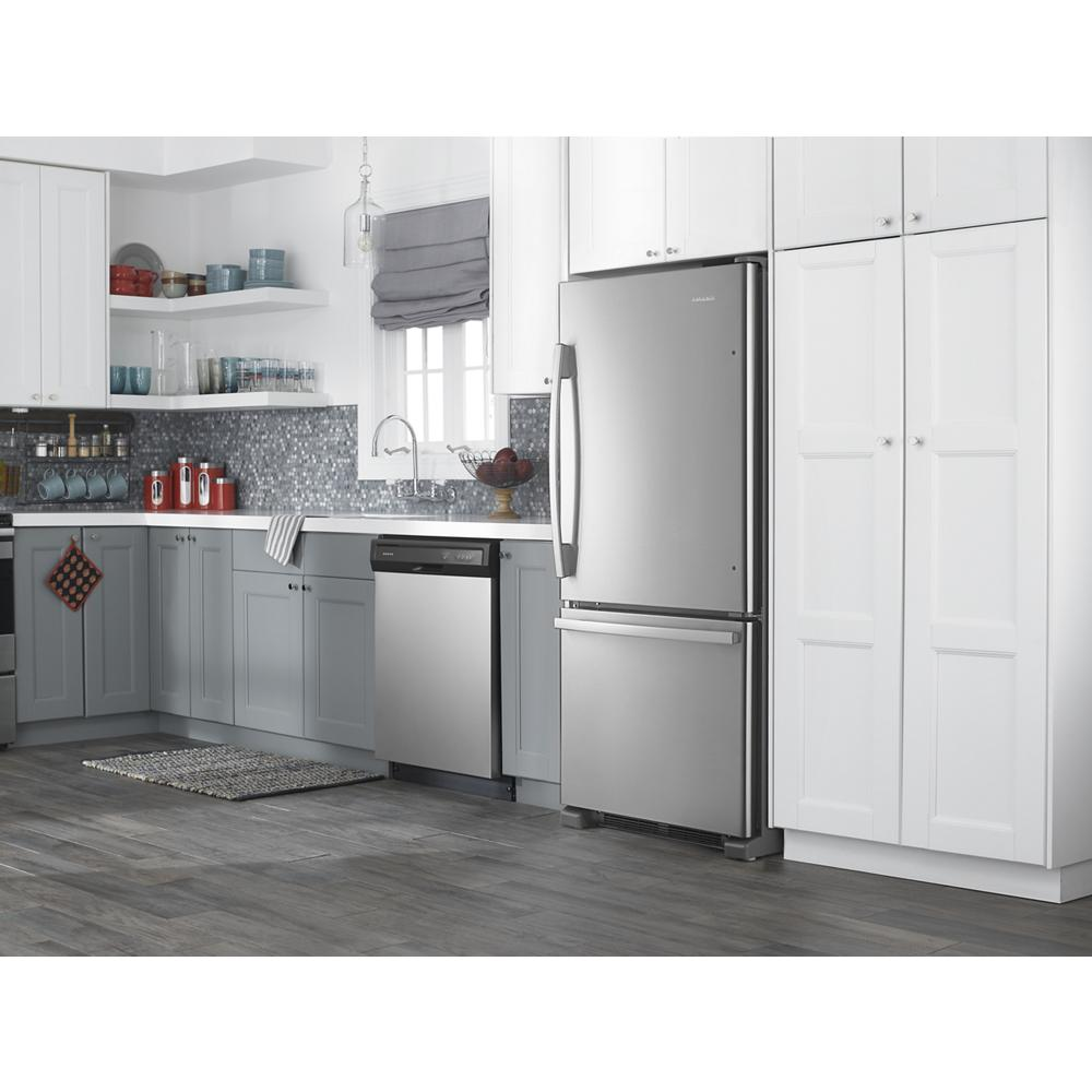 Modern kitchen with stainless steel bottom-freezer refrigerator, dishwasher, gray cabinets, and white upper cupboards