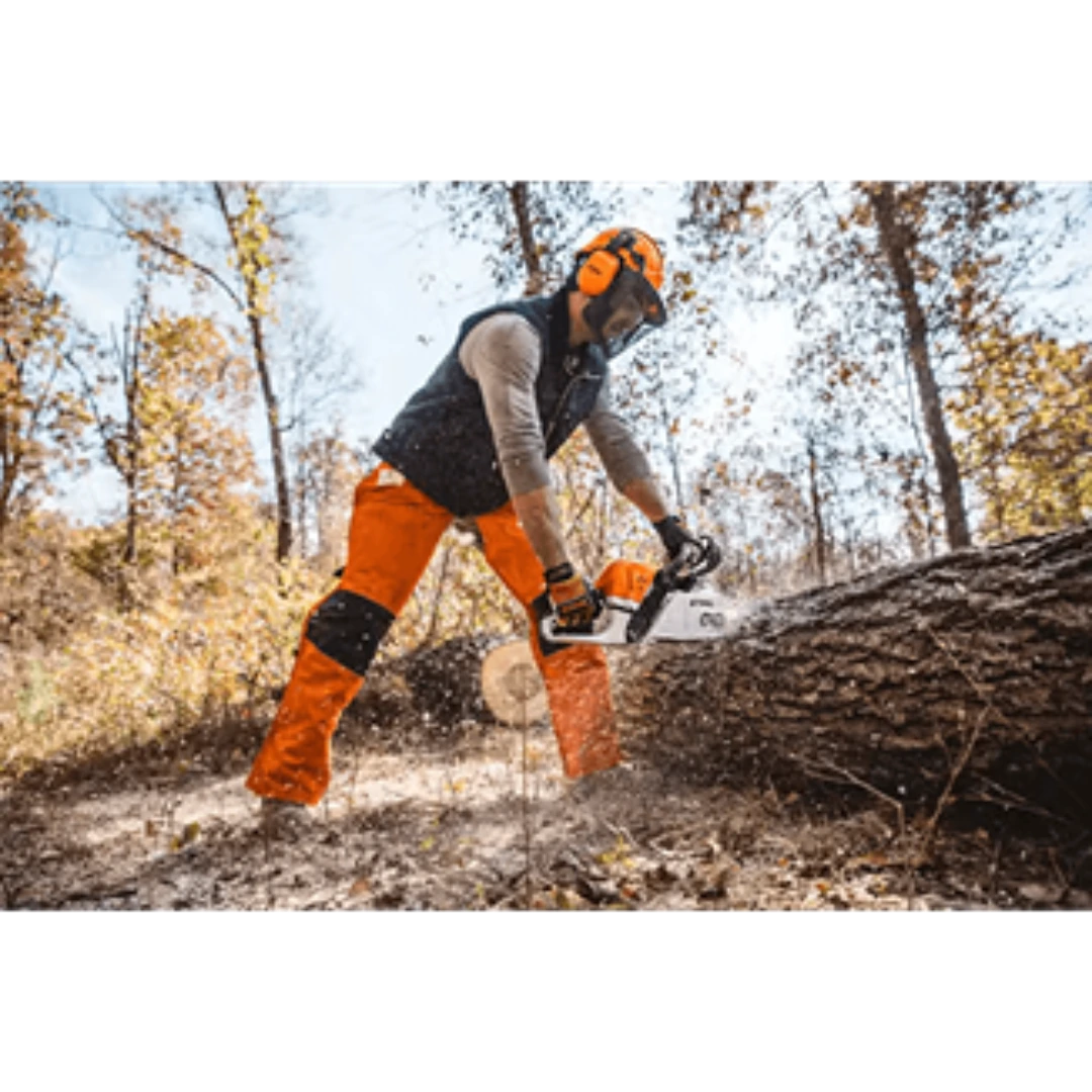 Person wearing safety gear operating a gas-powered chainsaw to cut large fallen tree in outdoor home improvement setting