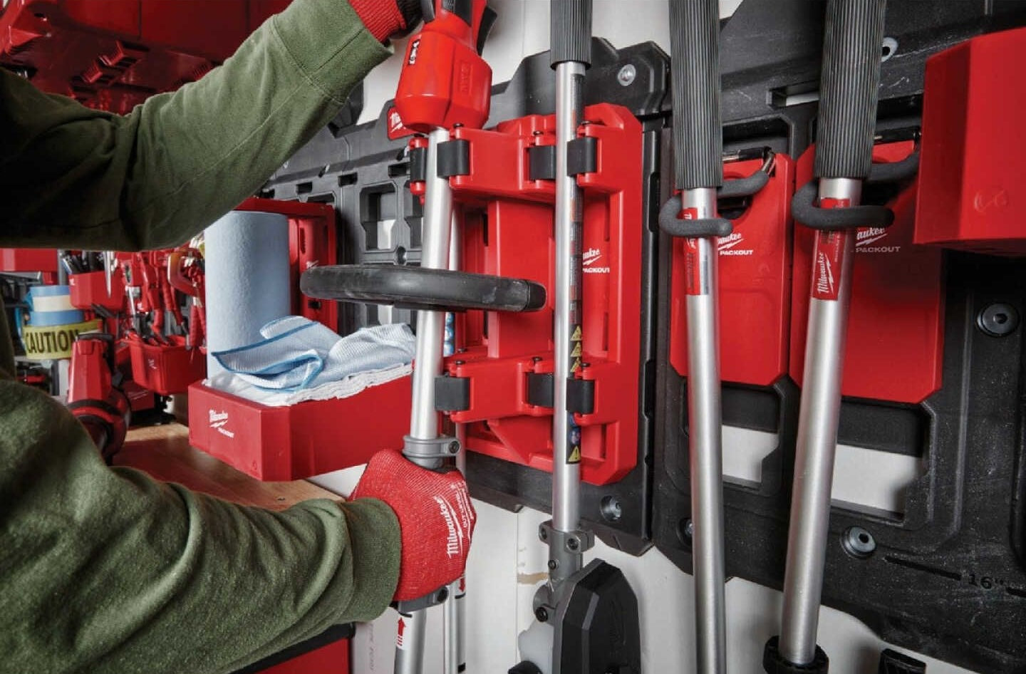 Red modular long handle tool rack with secure hooks for customizable storage in garage and workshop organization systems