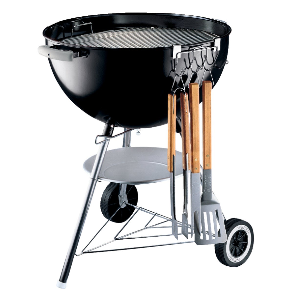 Black steel grill with wooden-handled grilling tools hanging from a steel tool holder for outdoor cooking and grilling accessories