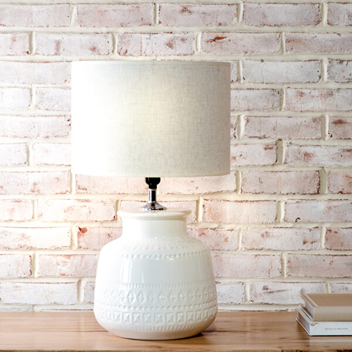 Table lamp with white textured ceramic base and light fabric shade, ideal for home lighting and décor under $100 collection