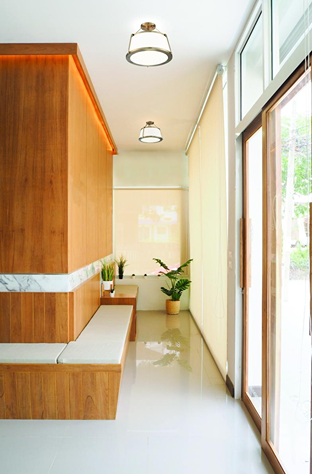 Three-light semi-flush burnished brass fixture with fabric shades illuminating modern bathroom hallway space