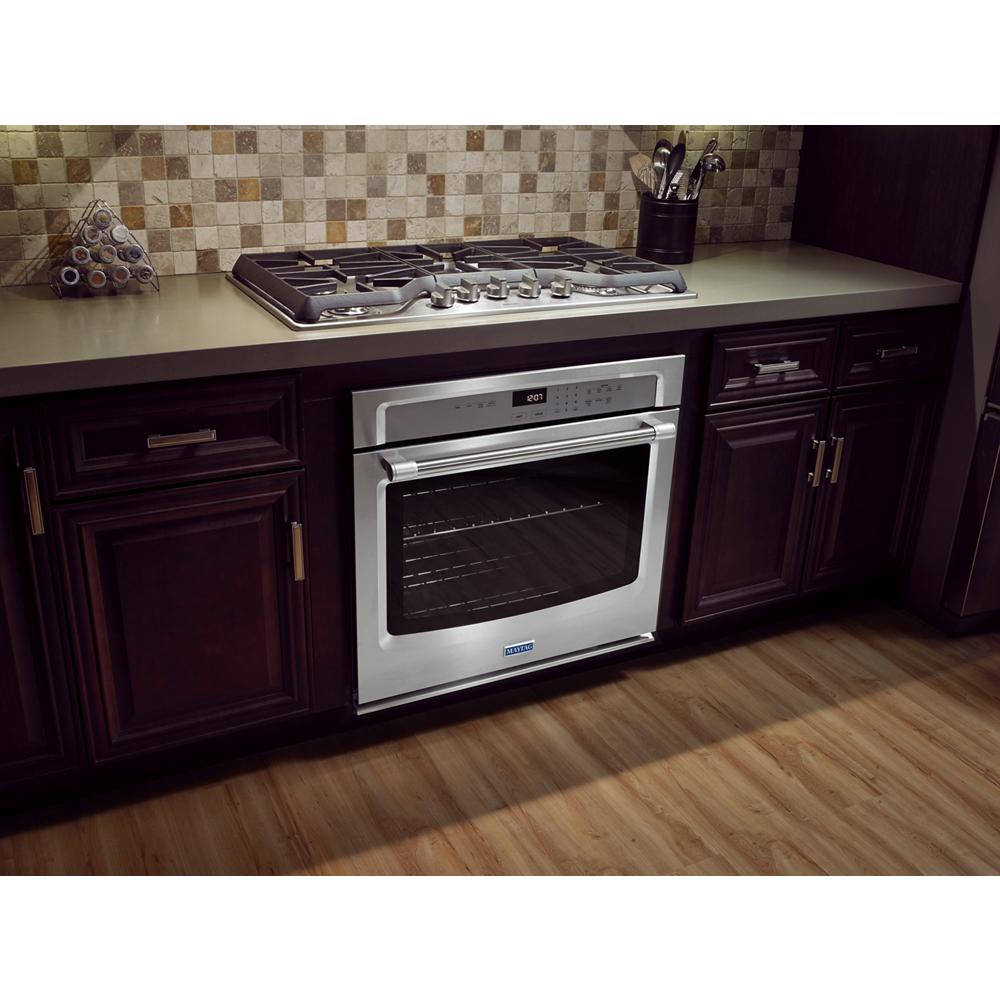 Built-in stainless steel gas cooktop with multiple burners installed on kitchen countertop in home improvement collection