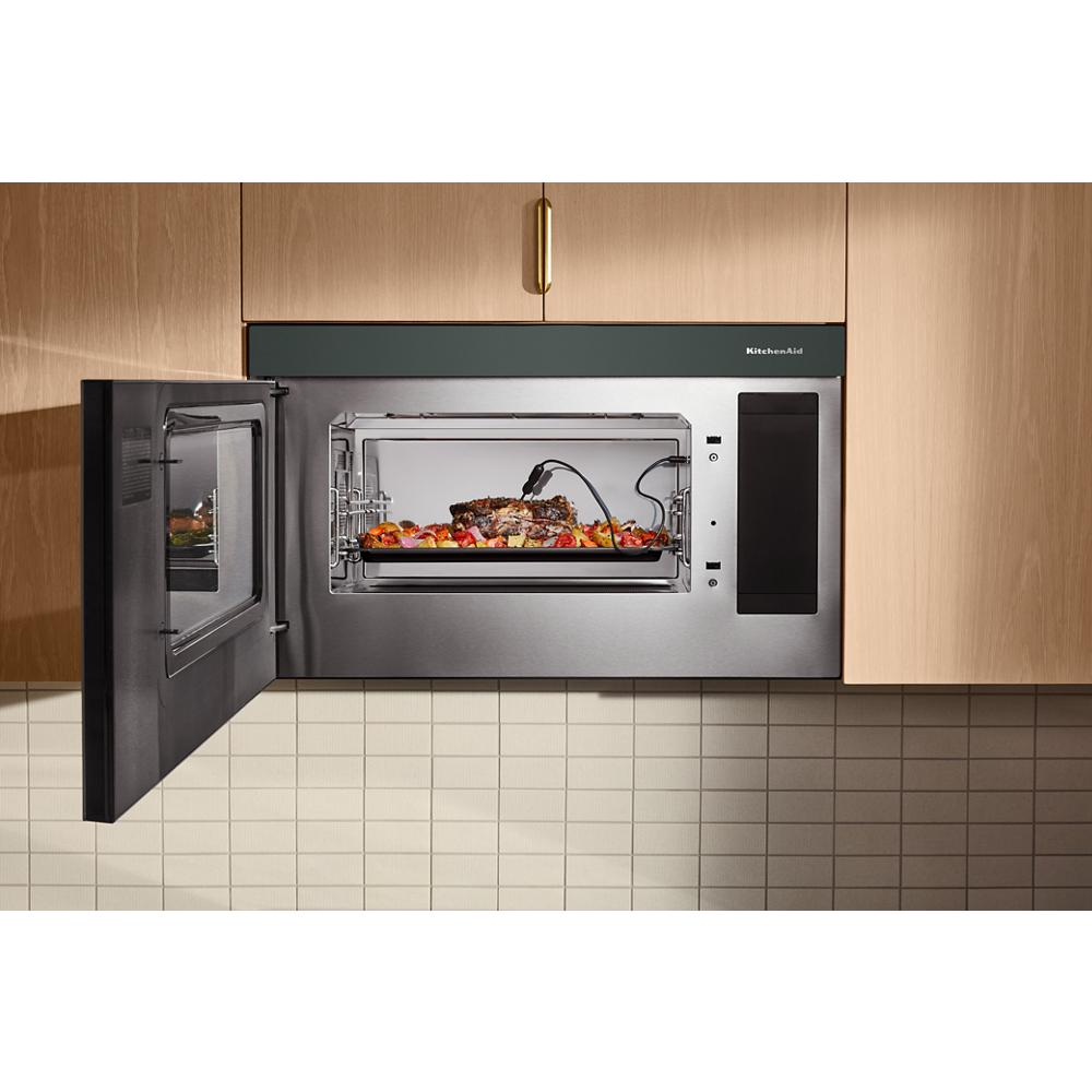 KitchenAid multifunction microwave oven with open door and meat thermometer probe cooking steak and vegetables inside