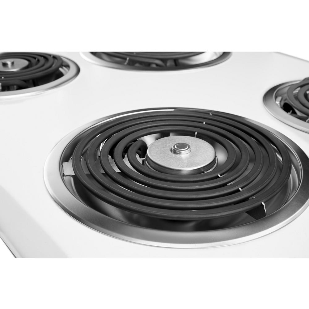 Close-up of white electric cooktop coil burner with black spiral heating element for kitchen appliances use