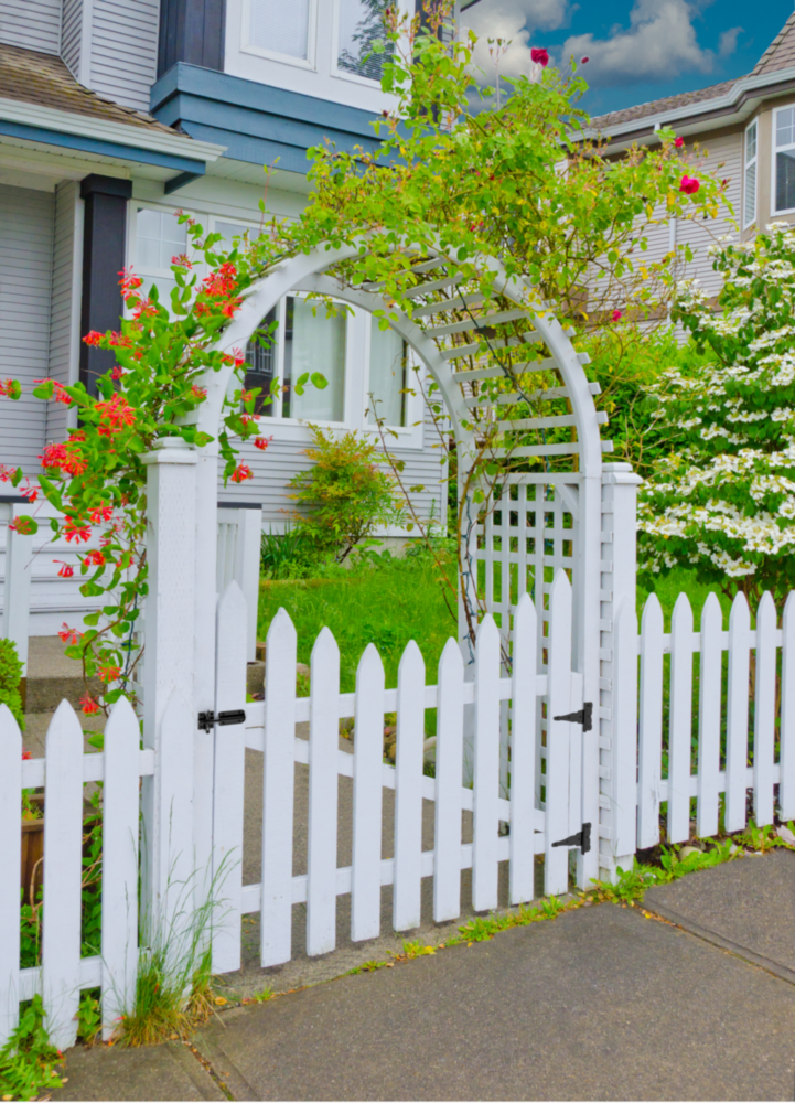White wooden garden gate with decorative arch and black decorative hinges in home and gate hardware settings