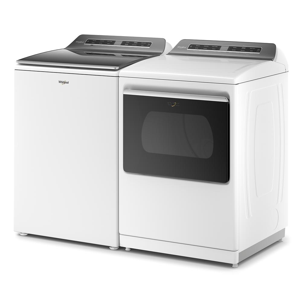 Set of white Whirlpool top load washer and electric dryer with digital control panels in home appliance setting
