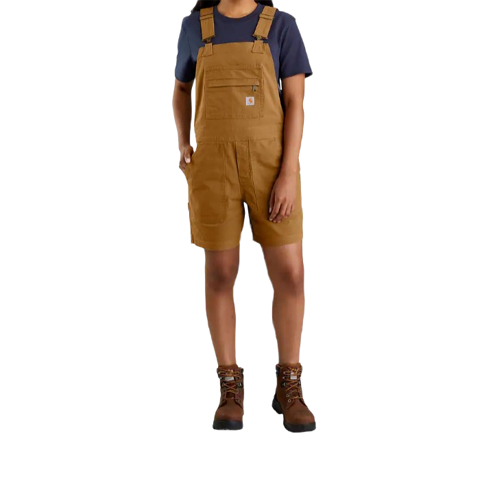 Woman wearing medium brown relaxed fit canvas shortall with adjustable shoulder straps and workwear boots