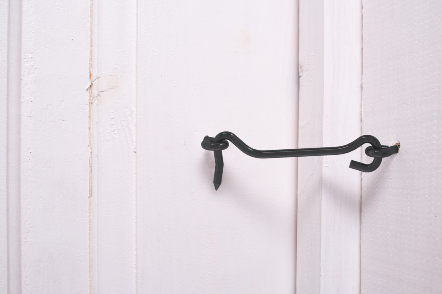 Black 4-inch hook and eye latch on white wooden door for secure fastening in door accessories and home improvement under $50