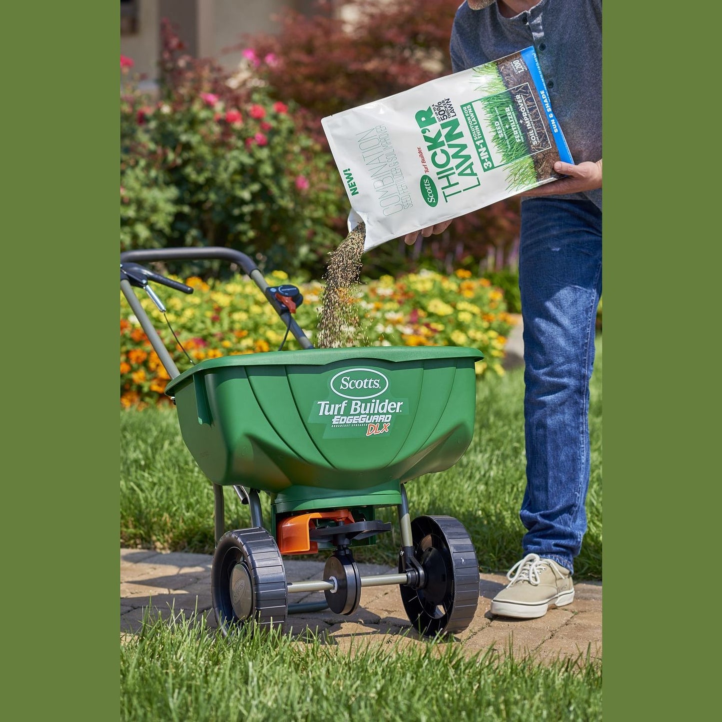 Person pouring Scotts grass seed mix into green Scotts Turf Builder spreader for lawn care and grass seed applications
