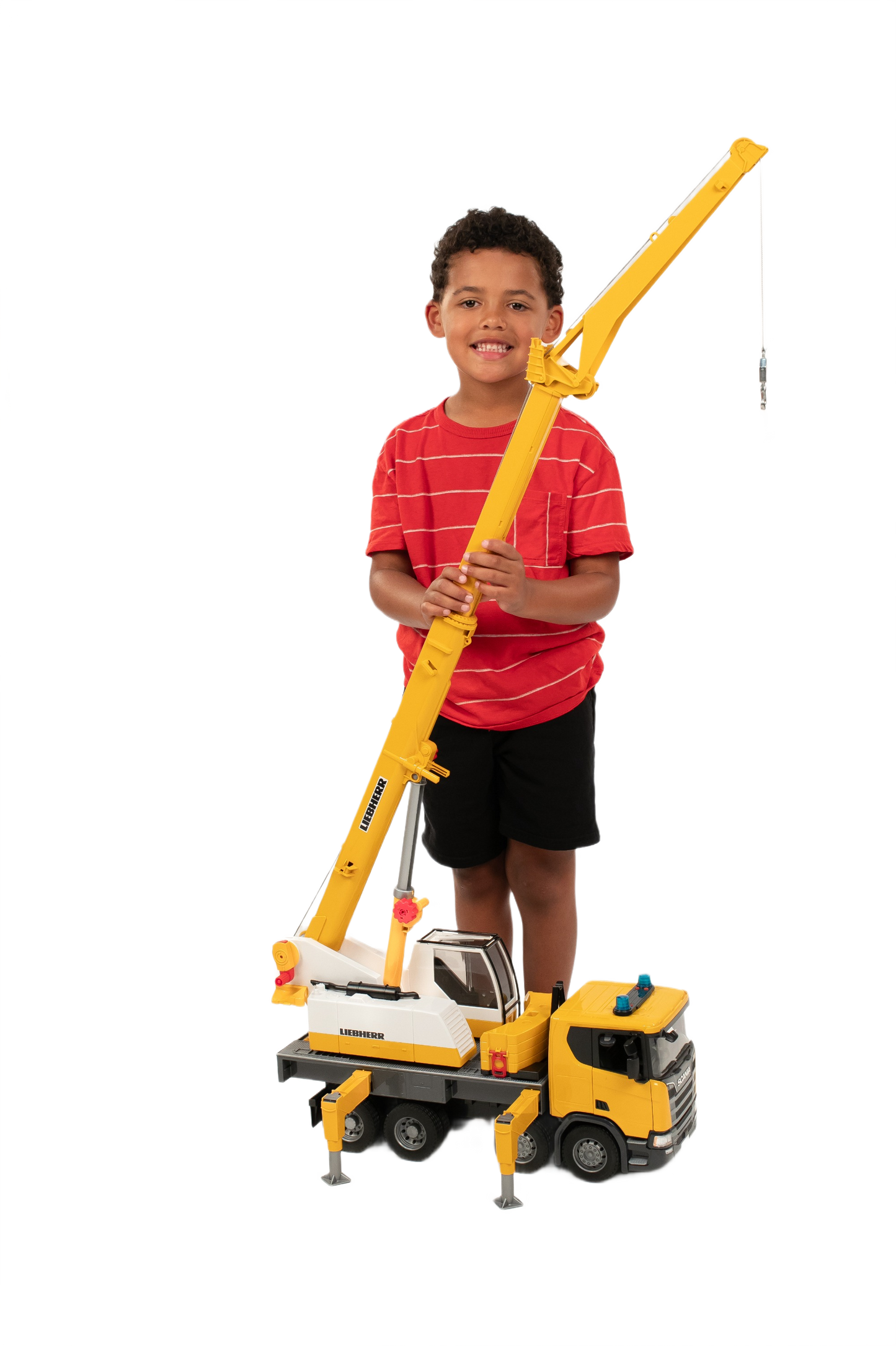 Child standing with Bruder yellow and white Scania crane truck model with fold-out boom in Toys & Games collection
