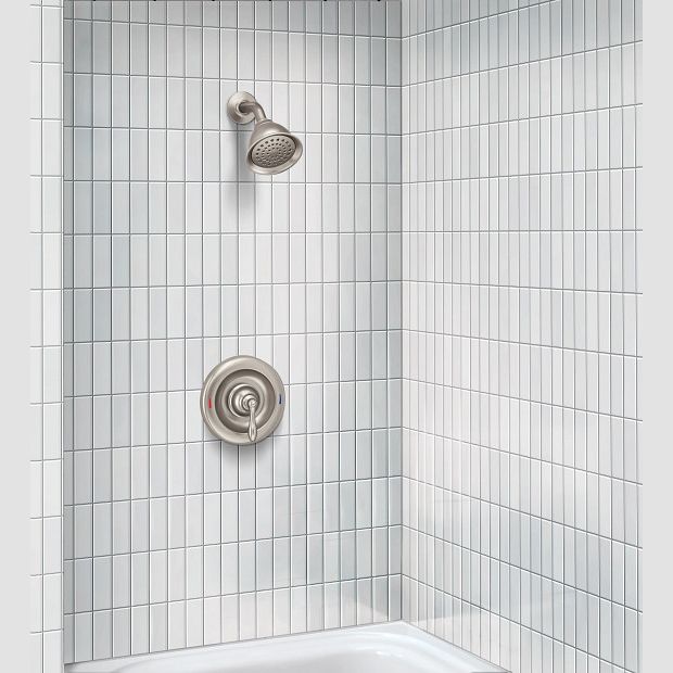 Shower trim set in brushed nickel with single-handle lever and round showerhead in white tiled bathroom corner