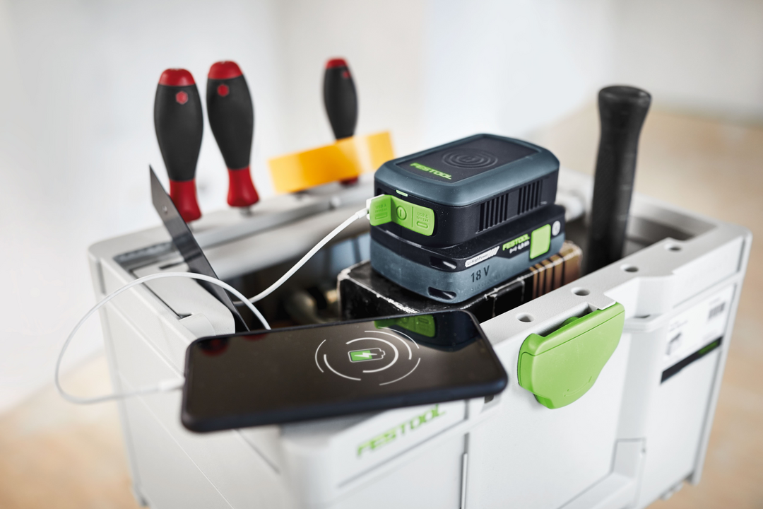 Festool 18V battery powering smartphone via charger adapter on tool storage box, featured in portable power accessories collection