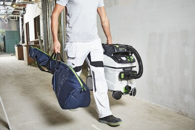 Person carrying navy blue reinforced carrying bag designed for drywall sander storage in woodworking tool accessories collection