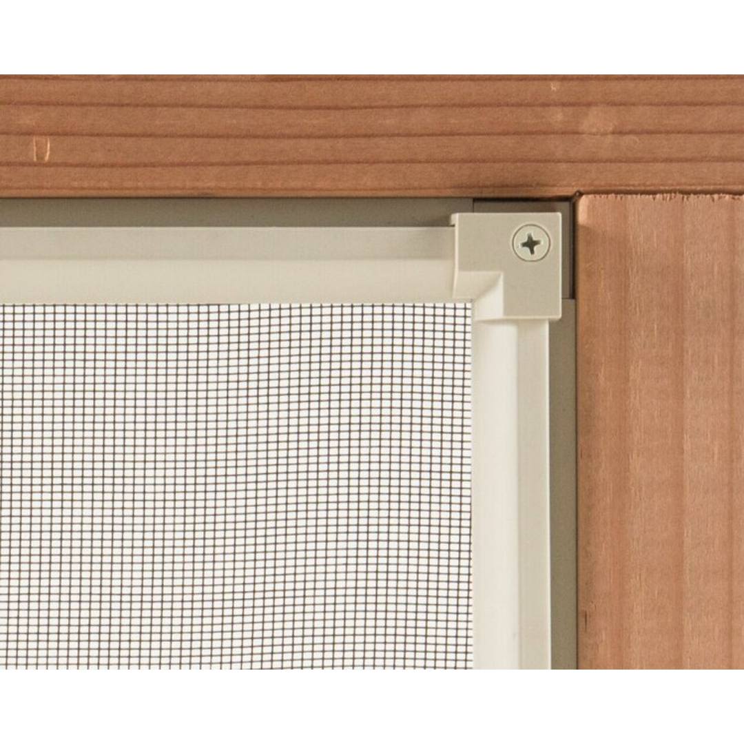 Close-up of white plinth flush kit corner component installed on wooden door frame in door accessories and home improvement collections