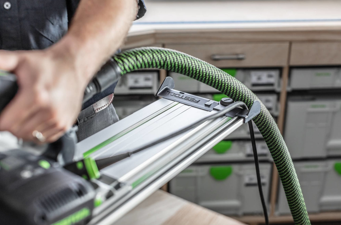 Close-up of Festool guide rail deflector with green dust extraction hose in woodworking tool accessories collection