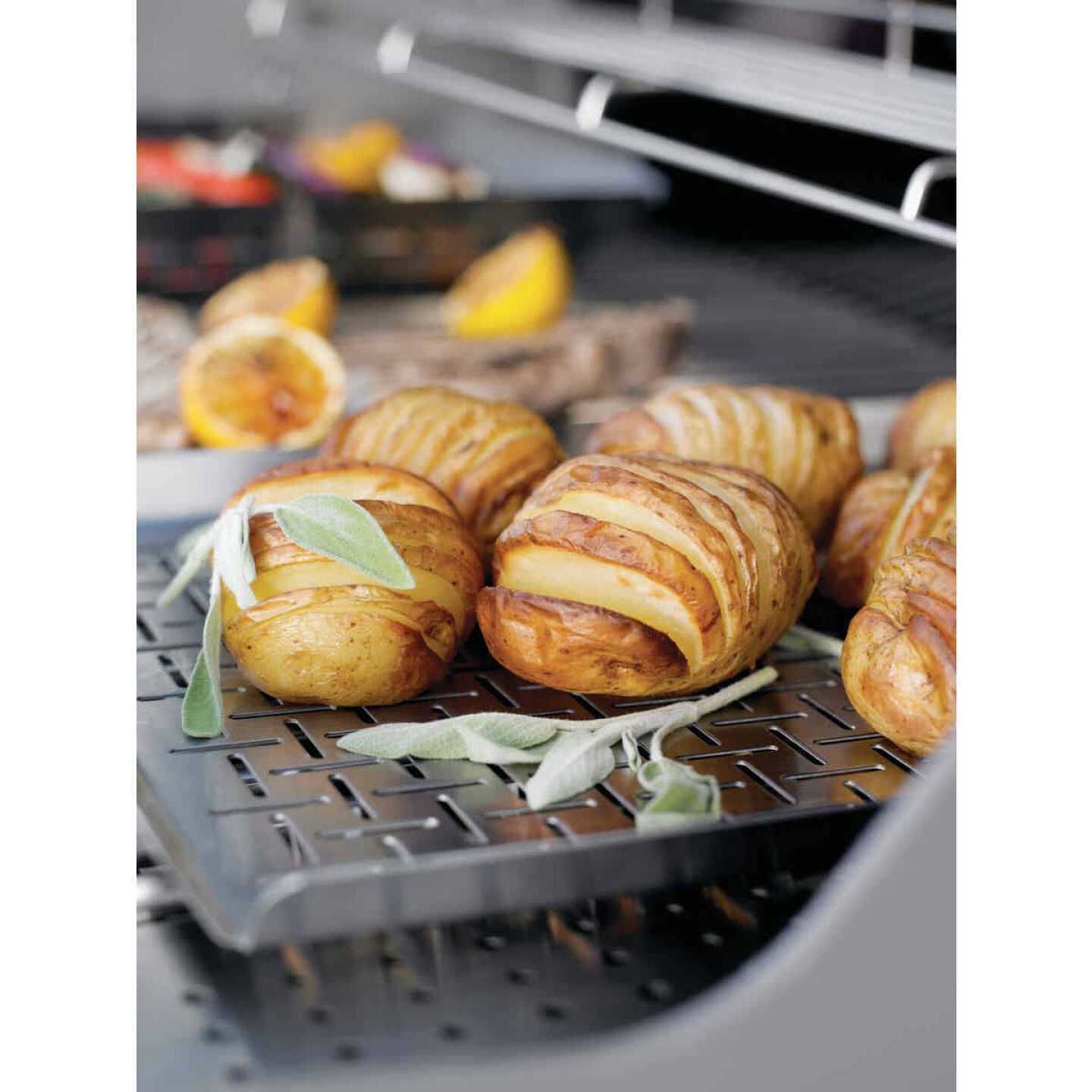 Stainless steel grilling pan with sliced potatoes and herbs cooking on a grill for home improvement tasks