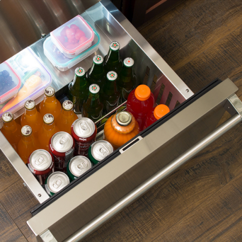 Stainless steel refrigerated drawer with adjustable dividers storing beverages and containers in kitchen appliances collection