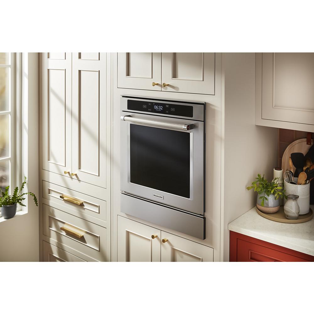 Built-in stainless steel smart wall oven with digital display integrated into a modern kitchen cabinetry setup