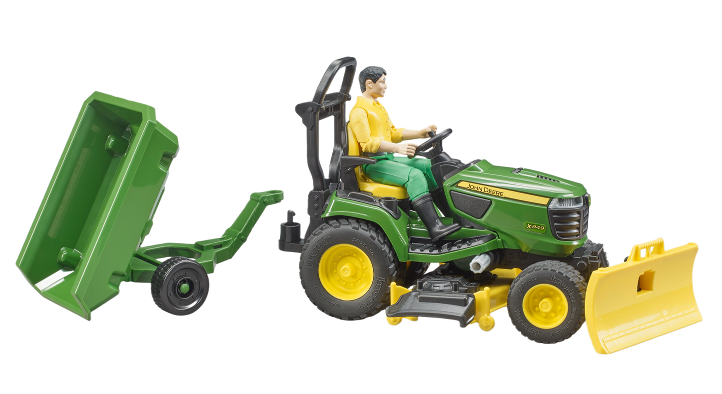 Green John Deere riding tractor toy with man figure, attached trailer, and front blade for outdoor power equipment collections