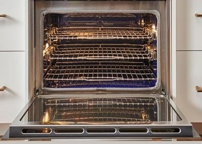 Open stainless steel built-in oven with interior racks lit, from wall ovens and kitchen appliances collection
