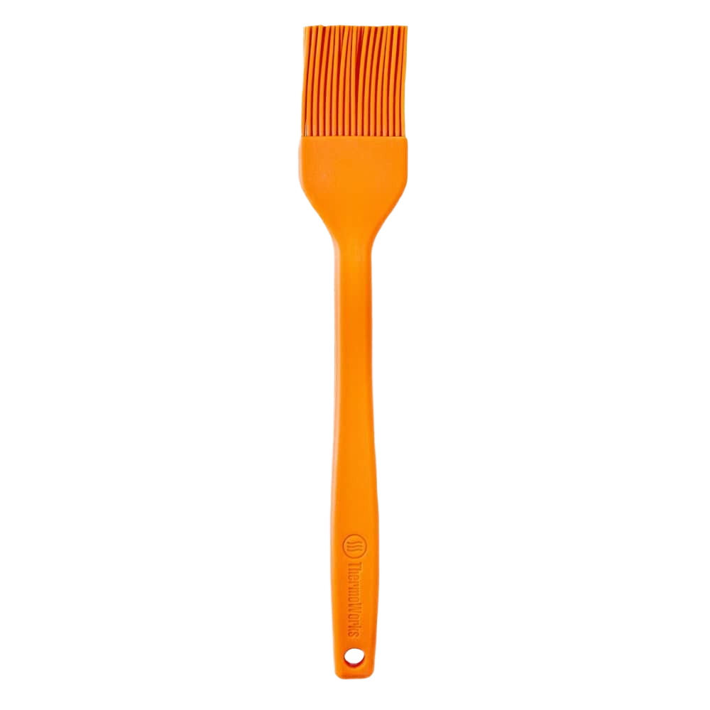 Orange silicone brush with flexible bristles and ergonomic handle designed for high-temperature cooking and home improvement tasks
