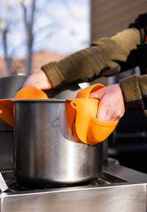 Orange silicone grill mitts providing heat protection for safely handling hot cookware in grilling tools and outdoor living collection