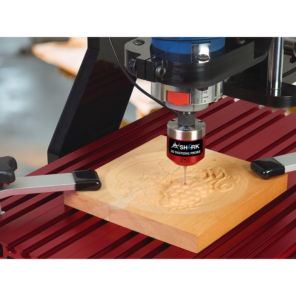 Close-up of CNC router using red 3D digitizing probe tracing detailed wood carving on red metal base for woodworking tools