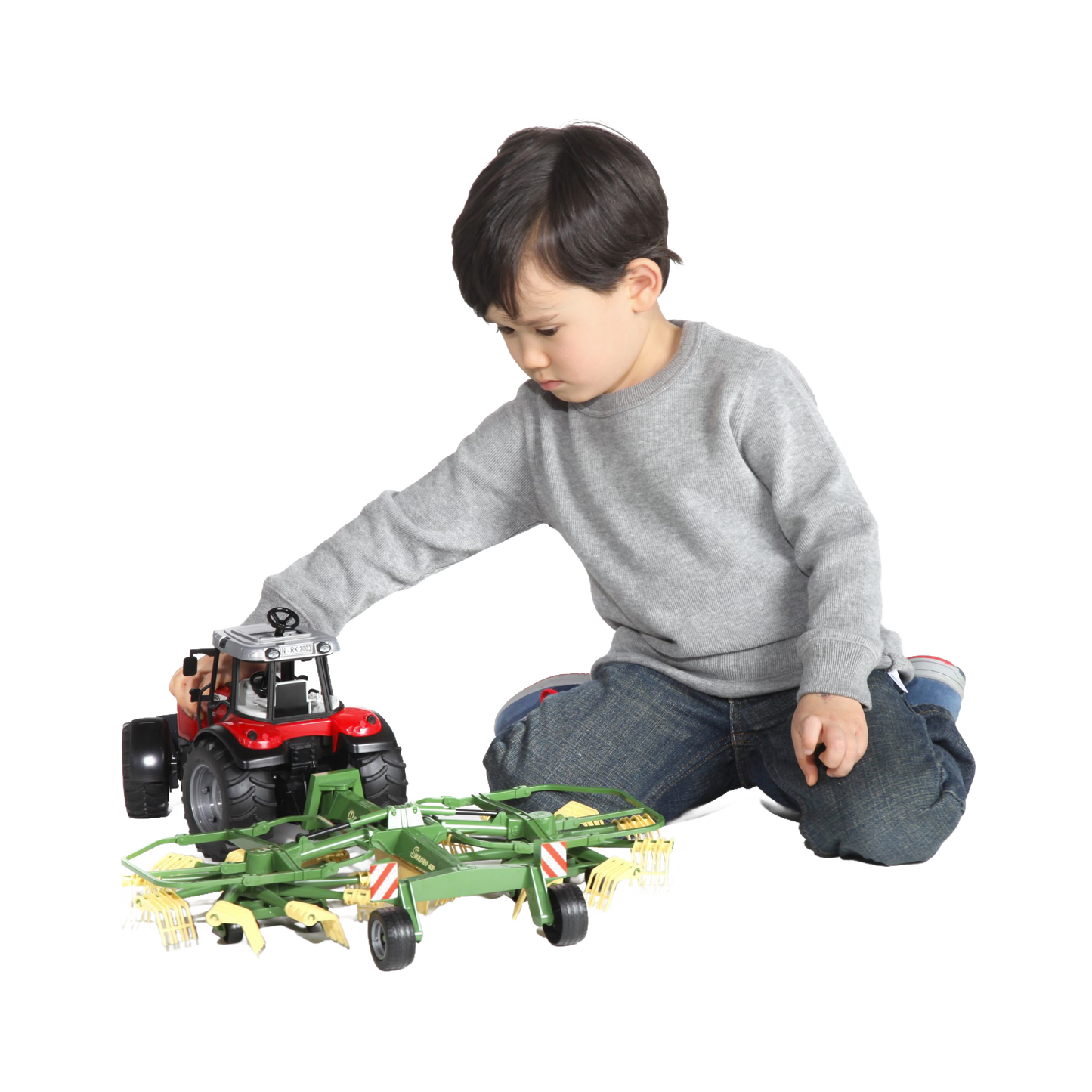 Young child playing with red tractor toy attached to green farming implement in vehicles and toys collection under $100