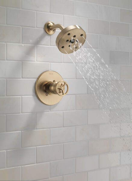 Modern champagne bronze shower faucet trim with wheel handle, installed on white subway tile wall for bathroom upgrade