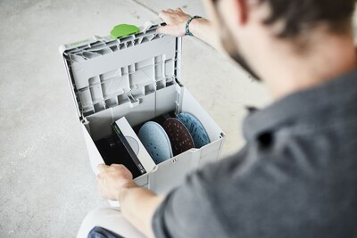 Gray plastic interlocking storage box open to organize circular abrasives for woodworking tool storage systems