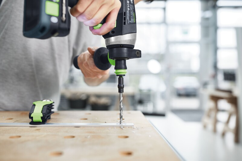 Handheld drill with a spiral drill bit drilling precise holes in wood for power tool accessories and home improvement