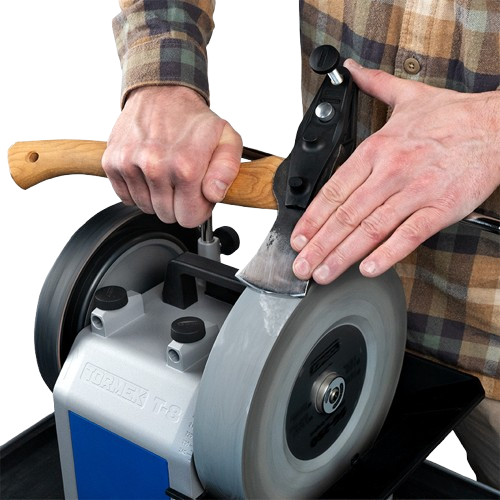 Person sharpening an axe blade using a jig mounted on a sharpening wheel for precise edge maintenance in home improvement tasks