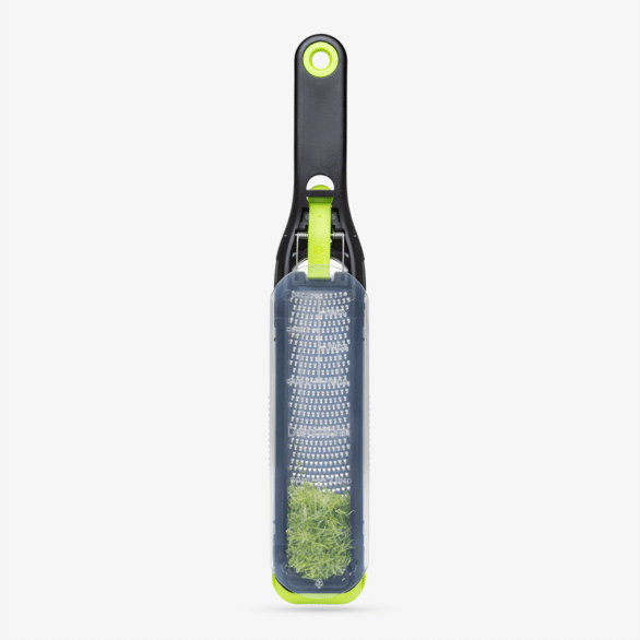 Black and lime green self-cleaning zester with stainless steel grater for kitchenware and cooking utensils collections