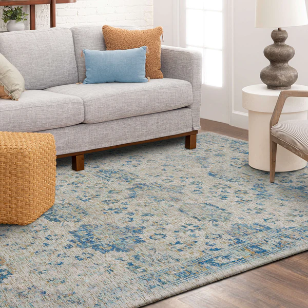 Soft blue patterned rug with subtle distressed details placed under modern living room furniture for home decor.