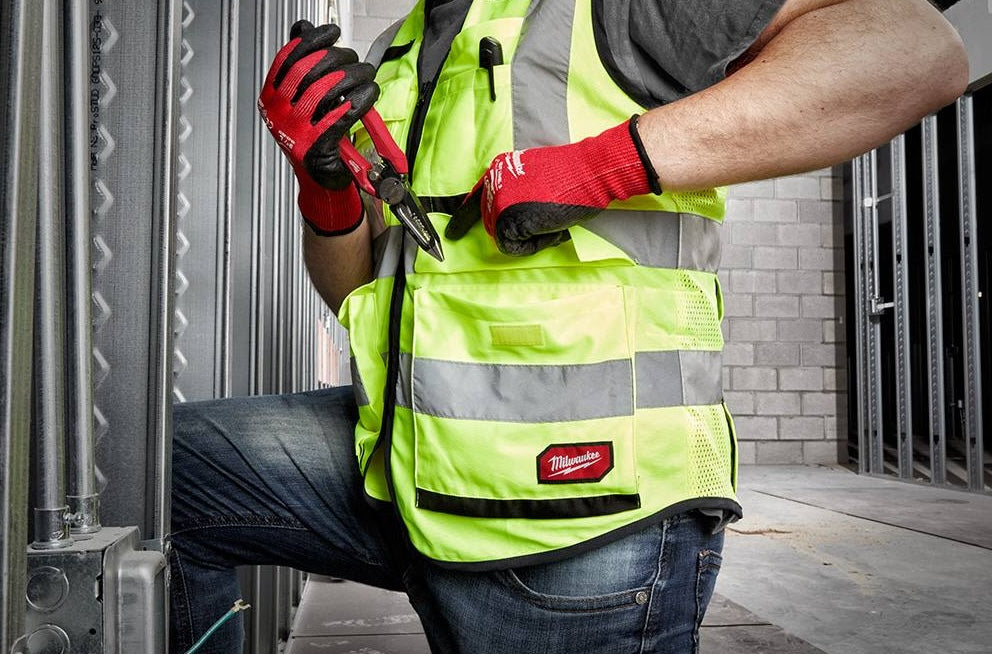 High visibility yellow safety vest with reflective stripes and reinforced pockets worn during home improvement work