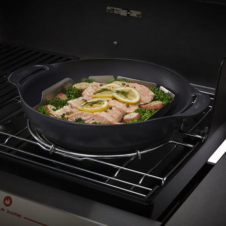 Cast iron wok with cooked salmon and vegetables on gas grill in outdoor cooking and grilling accessories collections