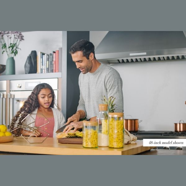 Father and daughter preparing food in kitchen with pyramid chimney wall hood from Thermador appliances collection