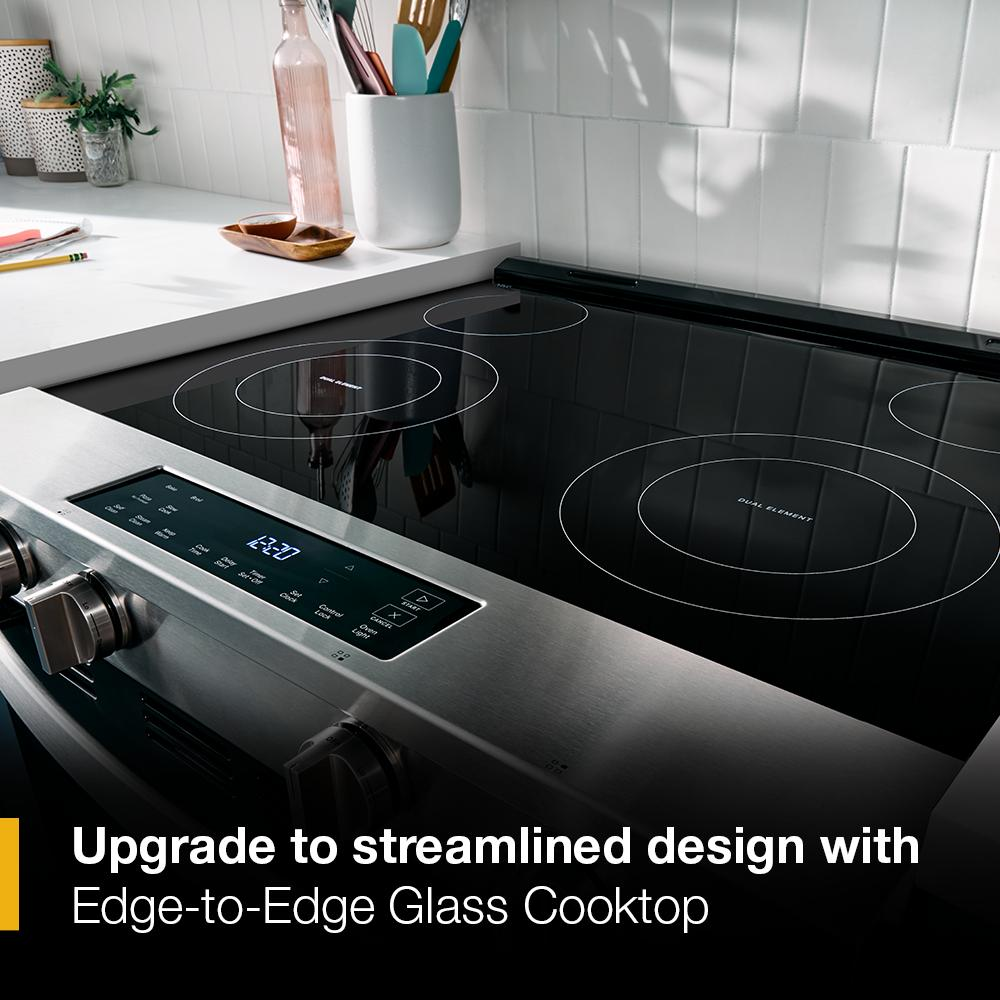 Stainless steel electric range featuring edge-to-edge glass cooktop with touch controls in modern kitchen setting