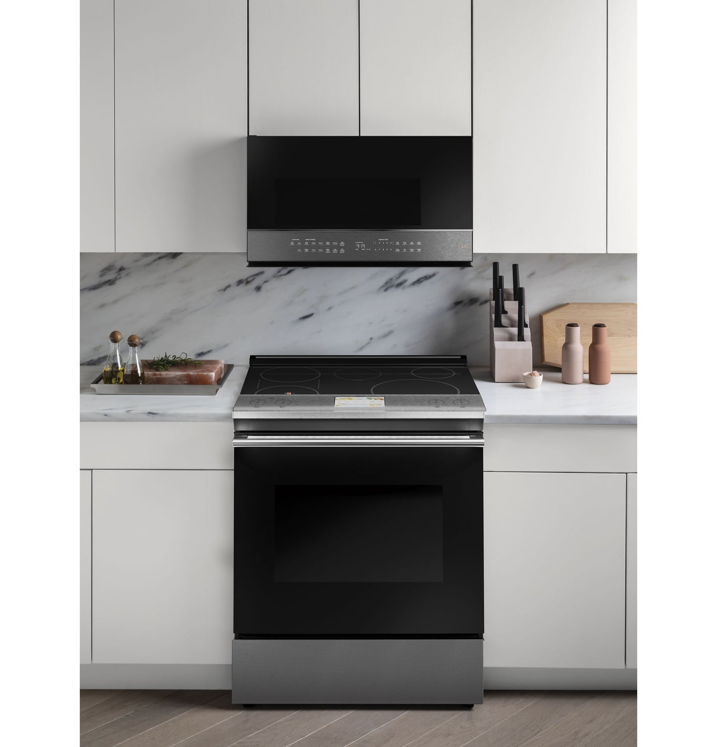 Black and stainless steel electric range with smooth cooktop and smart over-the-range microwave in kitchen setting