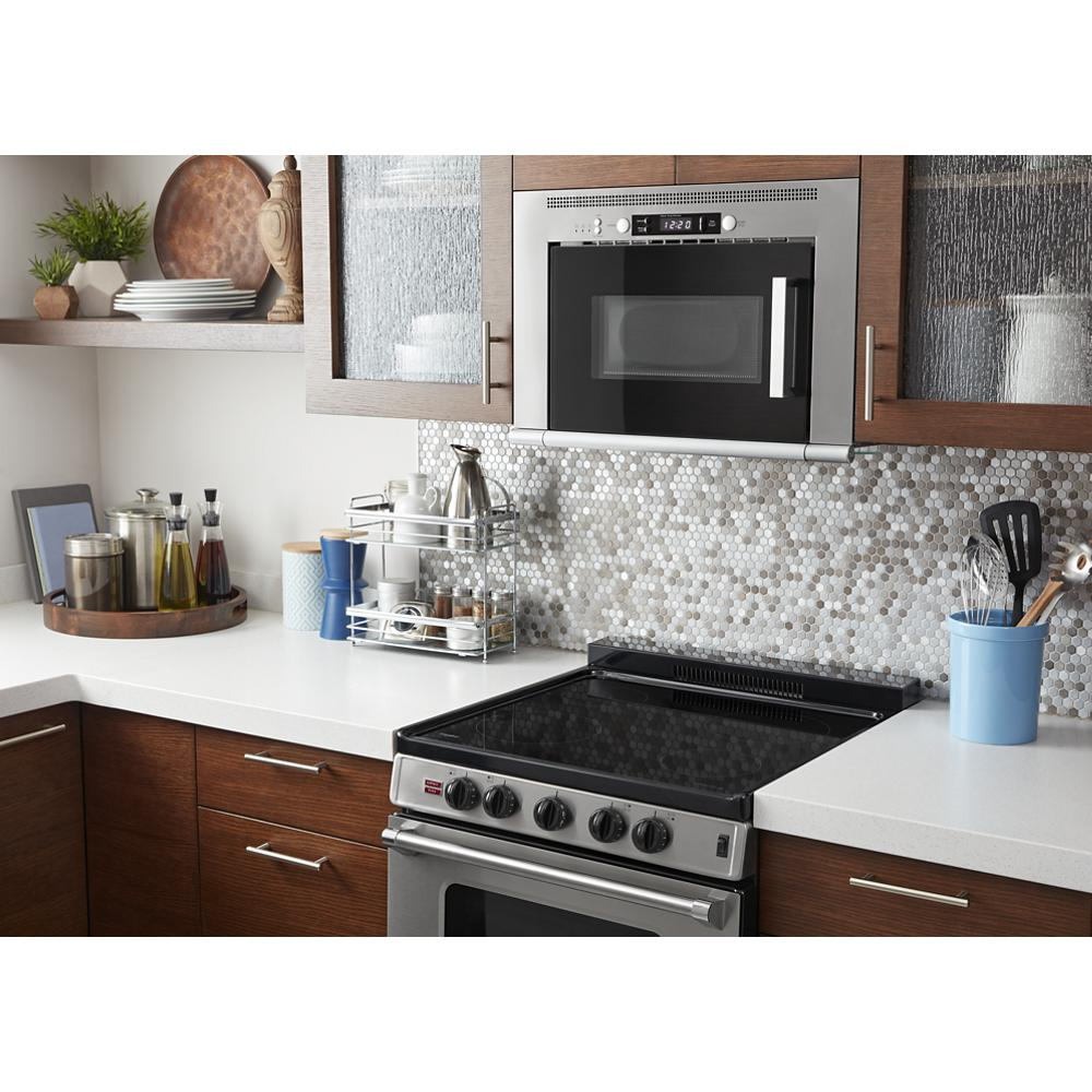 24-inch freestanding electric range with smooth black cooktop below stainless steel microwave in modern kitchen setting