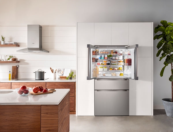 Built-in style stainless steel French door refrigerator with bottom freezer in modern kitchen setting from Bosch Appliances collection