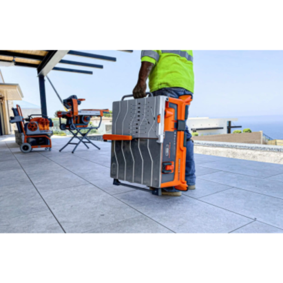 Person carrying a compact orange and gray tabletop tile saw on a patio for home improvement tools collection