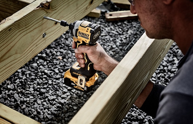 DEWALT yellow and black cordless impact driver with 3-speed control being used for outdoor home improvement tools task