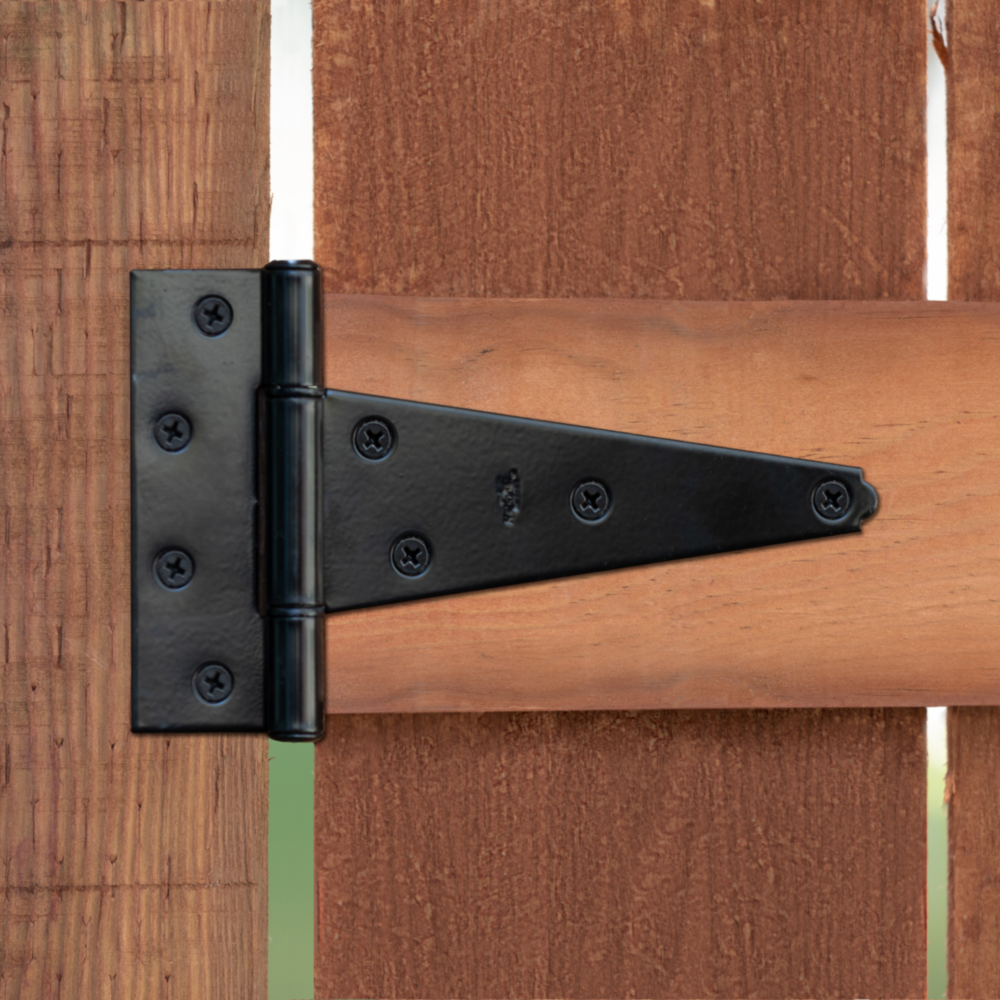 Black heavy-duty tee hinge with multiple mounting screws on wood gate for outdoor home improvement projects