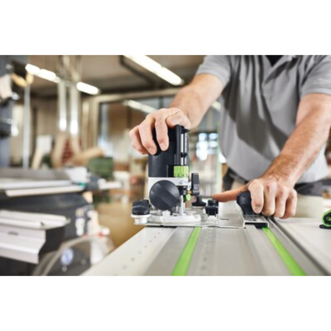 Craftsman operating a precision woodworking router along a Festool guide rail in a professional workshop setting