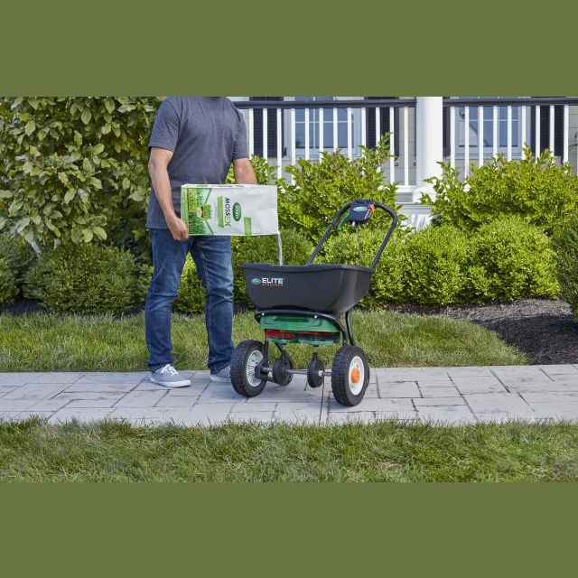 Person pouring Scotts MossEX granules into a lawn spreader for lawn care and garden maintenance tasks