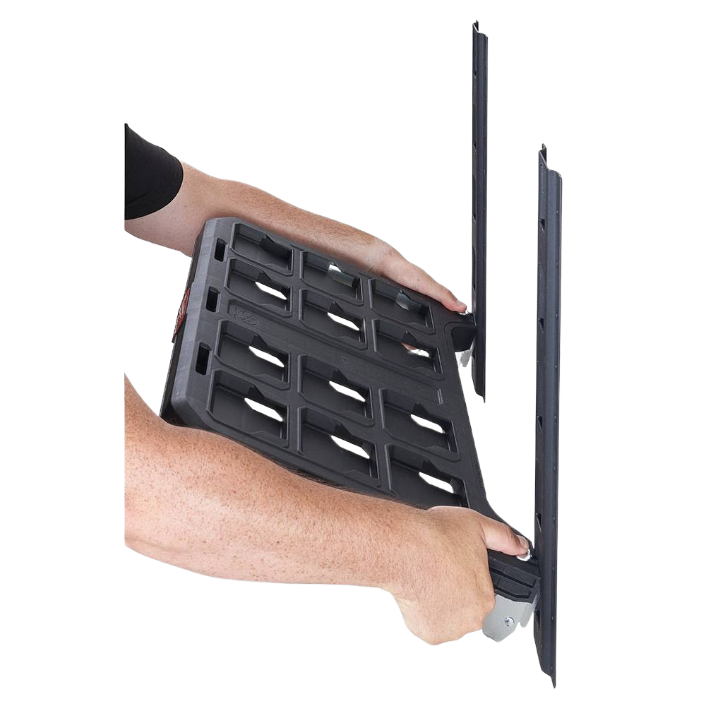 Black Milwaukee PACKOUT™ mounting shelf with grid pattern being installed on vertical rails for tool storage systems