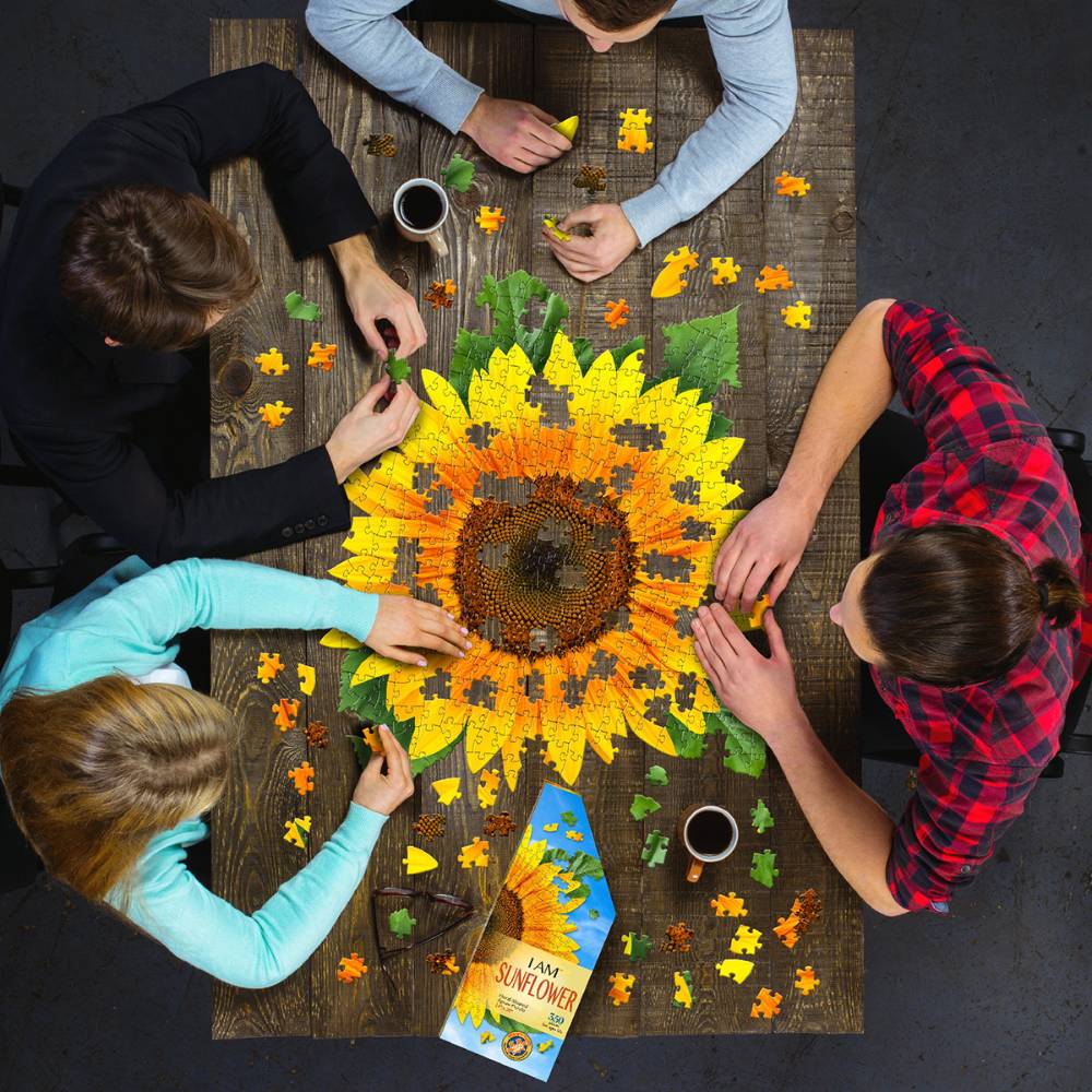 Group assembling vibrant sunflower shaped 350-piece puzzle on wooden table in toys and games collection under $50